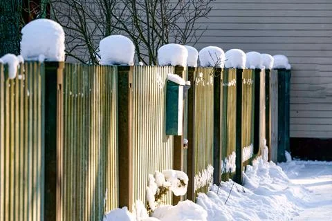 The fence posts are covered with white snow. Stock Photos