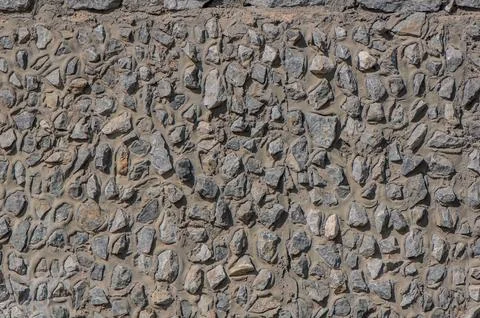 Fence real stone wall surface with cement as background. Stock Photos