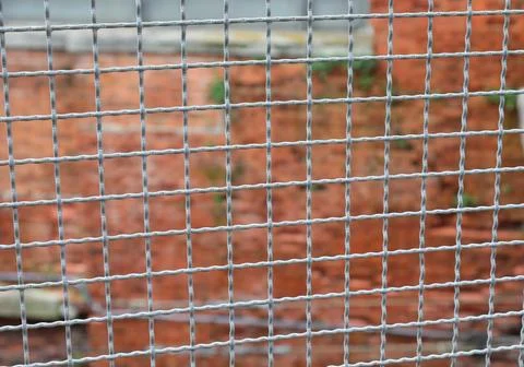 Fence separating the border and the brick wall of the penitentiary out of f.. Stock Photos