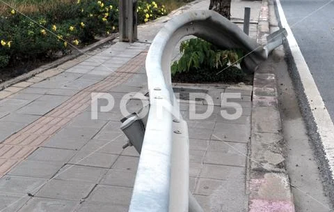 The fence on the side of the road in the curve of the road is distorted becau Stock Photos