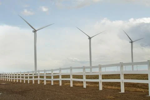 Fence that surrounds a wind farm while it creates power Stock Photos