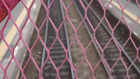 Fence at train station with view of train tracks in background Stock Footage 160763411