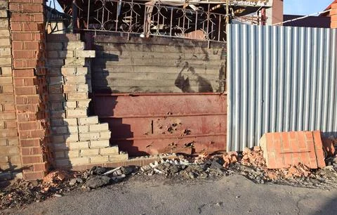 The fence was destroyed by a shell and covered with materials Stock Photos