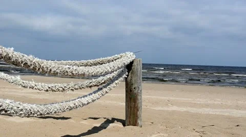Fence wooden log thick rope tie beach seaside sea wave Stock Footage