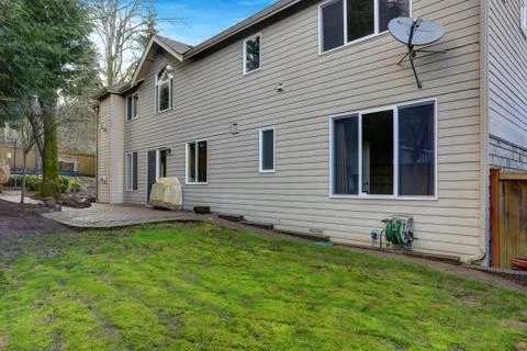 Fenced backyard with lots of space for entertaining offers patio space and ki Stock Photos