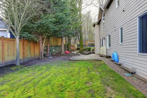 Fenced backyard with lots of space for entertaining offers patio space and ki Stock Photos