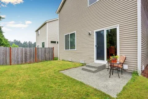 Fenced backyard with small patio area. Well kept lawn around. Northwest, USA Stock Photos