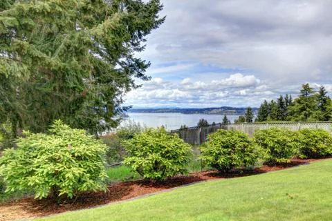 Fenced backyard with water view Stock Photos