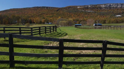 Fenced farm with a mountain and cliffs Stock Footage 32056132