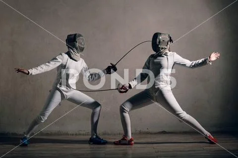 Photograph: Fencer woman with fencing sword. Fencers duel concept ...