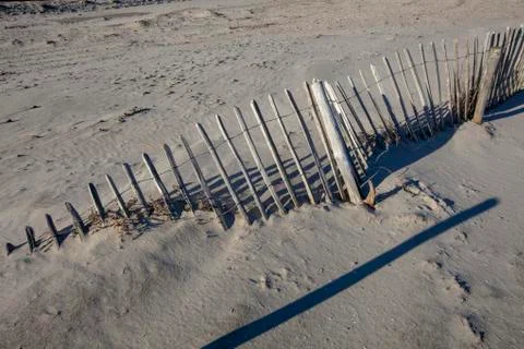A fench covered with sand in the foreground Stock Photos