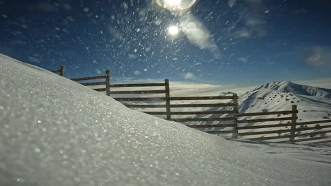 Fencing to prevent avalanches in mountains due to Wind Transport. Snowflakes fly Stock Footage 245521971