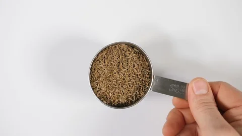 Fennel seeds in slow motion with a mans hand and sprinkling a stainless steel Stock Footage 88518134