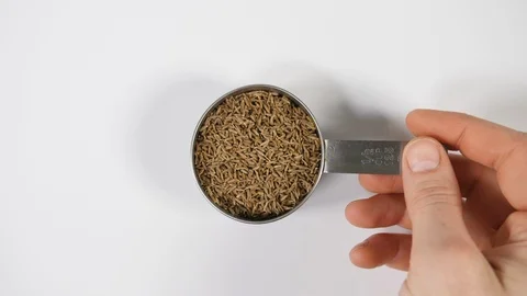 Fennel seeds in slow motion with a mans hand and spinning stainless steel Stock Footage 88518181