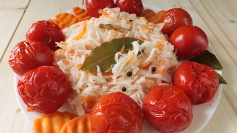Fermented cabbage and pickled tomatoes rotating on a plate Vídeo Stock 348309256