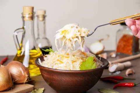 Fermented cabbage in ceramic bowl on table with spices and ingredients Stock Photos