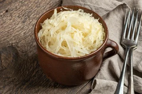Fermented cabbage on a table in a brown pot Stock Photos