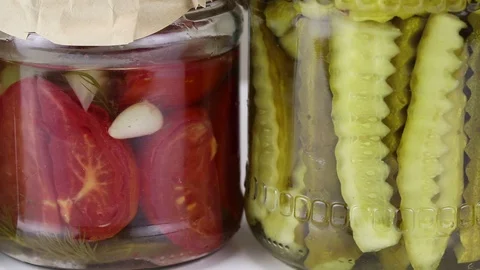 Fermented cucumbers and tomatoes in glass jars Stock Footage 121809211