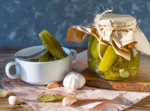 Fermented cucumbers on a dark background. Cucumber in a plate on a fork. Stock Photos