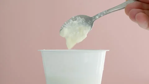 A fermented milk drink is mixed in a jar with a spoon. Stock Footage 311396696