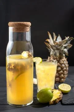 Fermented pineapple lemonade on a black background. Vertical frame Stock Photos