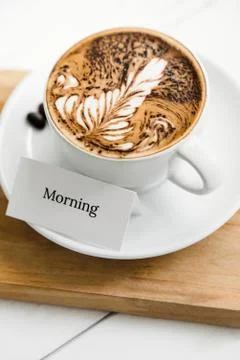 Fern pattern latte art coffee in the cup beside greeting text Stock Photos