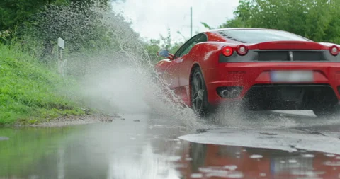 Ferrari speeds through a puddle Video stock 146768108