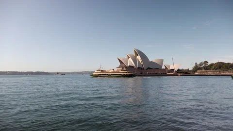 Ferries navigate the calm blue waters with the world-famous Sydney Opera House Vidéo 248952490