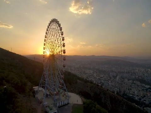 Ferris wheel in  amusement park on mountain and aerial panoramic view of  city Stock-Footage 80300192