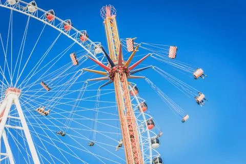 Ferris wheel and carousel with chains in an amusement park Stock Photos