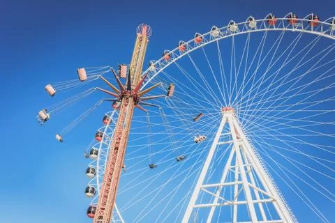Ferris wheel and carousel with chains in an amusement park Stock Photos