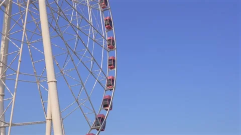 Ferris Wheel and Red Gondolas Against Blue Sky from Below Stock Footage 331336392