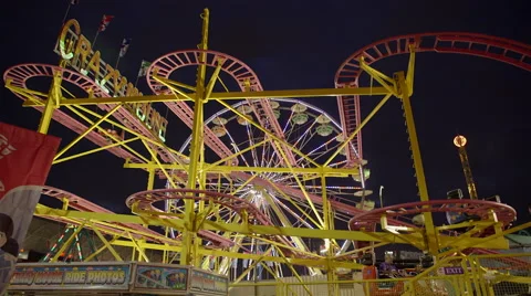 Ferris wheel and roller coaster at amusement park at night. 4K UHD. Stock Footage 54302191