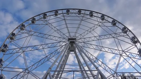 Ferris wheel on a background of blue sky and clouds. Entertainment park 動画素材 194383563