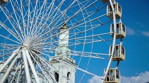 The Ferris wheel on the background of the chapel and the blue sky on Podol Stock Footage 91810360