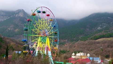 Ferris wheel on a background of mountains and forests in the Yalta Stock Footage 84737495