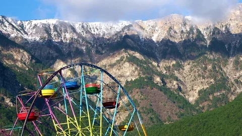 Ferris wheel on a background of mountains and forests in the Yalta Stock Footage 84737944