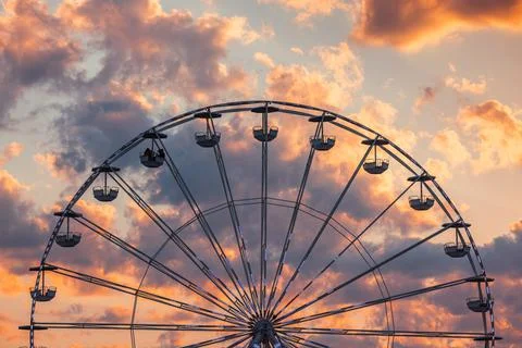 Ferris Wheel with clouds in sky, dramatic sunset cloudscape Foto stock