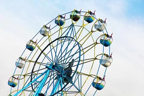 Ferris wheel on cloudy sky background. Stock Photos