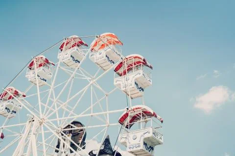Ferris wheel on cloudy sky background with vintage toned. Stock Photos