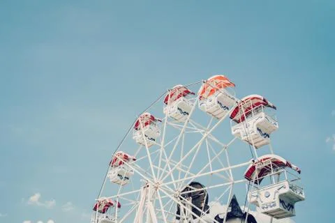 Ferris wheel on cloudy sky background with vintage toned. Stock Photos