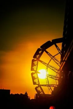 Ferris wheel colored by the setting sun Stock Photos