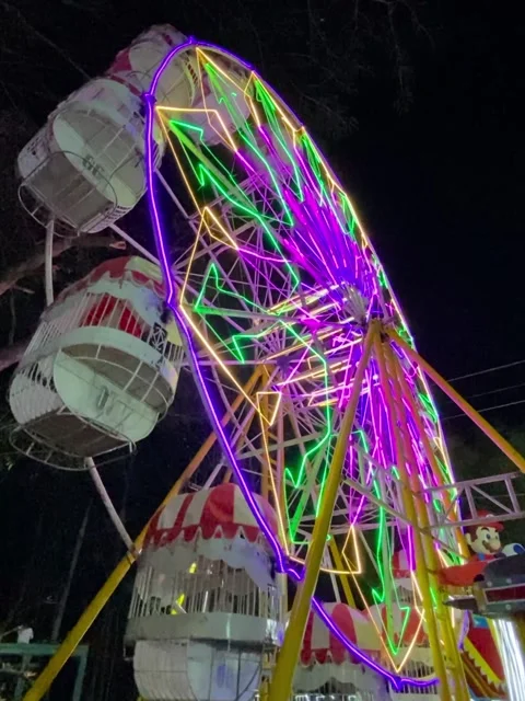 A Ferris wheel with colorful lights rotating at a night market. Stock Footage 321908376
