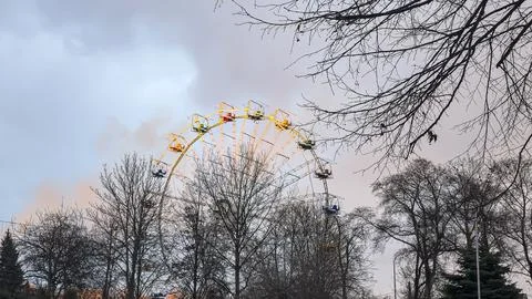 A Ferris wheel in the rays of the setting sun in a winter city park. 写真素材