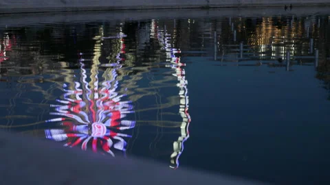 Ferris Wheel Reflected in Water at Night with Bright City Lights Stock Footage 323916700