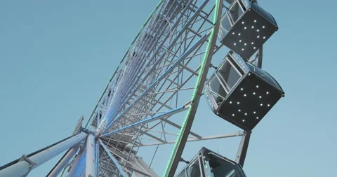 Ferris wheel rises. Bottom side view. Daytime, metal wheel design with LED Vídeos de archivo 197055341