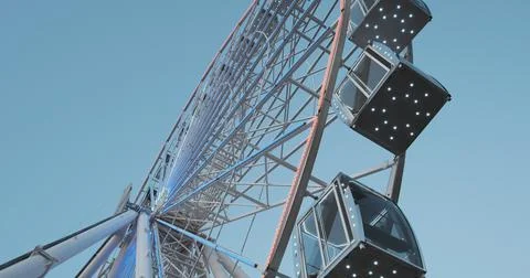 Ferris wheel rises. Bottom side view. Daytime, metal wheel design with LED Foto stock