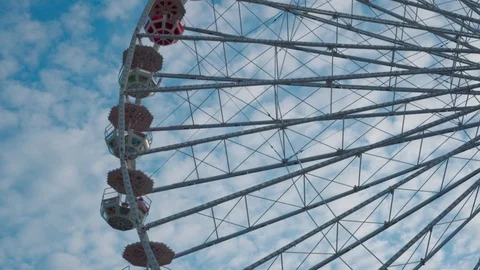 Ferris wheel rotates on the background of passing clouds in the blue sky. Stock Footage 114511824
