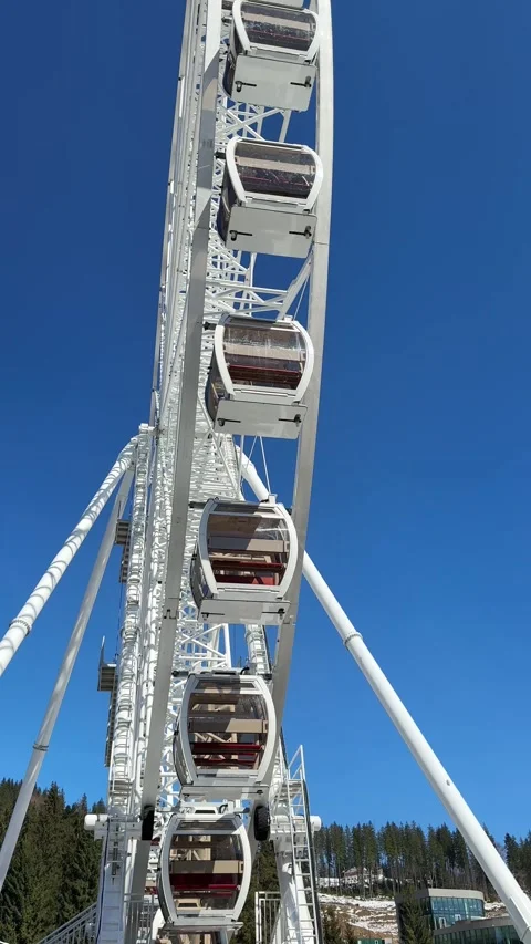 Ferris wheel rotating against clear blue sky in amusement park Stock Footage 309481326