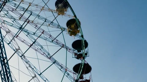 Ferris wheel rotating on the blue sky background, during the evening Vidéo 257799241